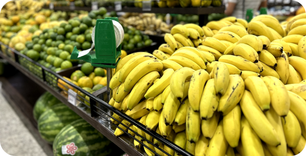 seção de hortifruti com a gondola de banana e outras frutas ao fundo